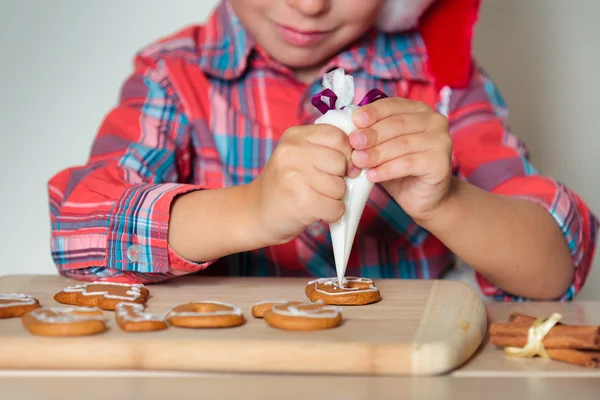 Close up of kid decorating the gingerbread cookies — Stock Photo, Image