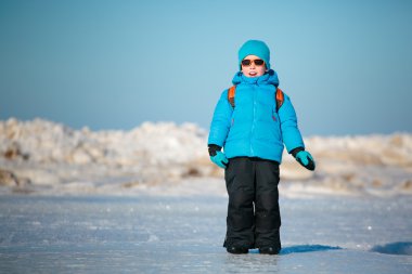 Kış sahilde oynarken sevimli küçük çocuk
