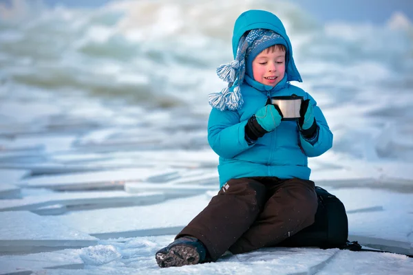 Carino bambino che beve tè caldo in inverno — Foto Stock