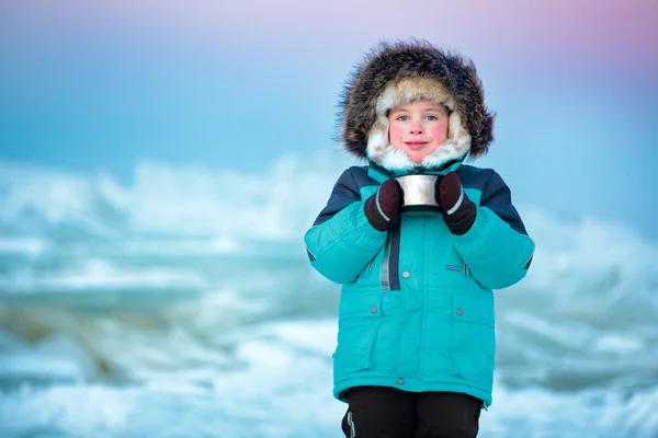 Carino cinque anni ragazzo bere tè caldo in inverno — Foto Stock