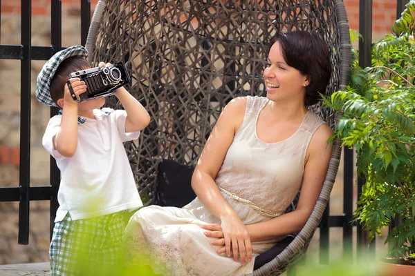 Menino com uma câmera retro e sua mãe — Fotografia de Stock