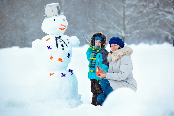 Little boy with his mother painting a snowman — Stock Photo, Image