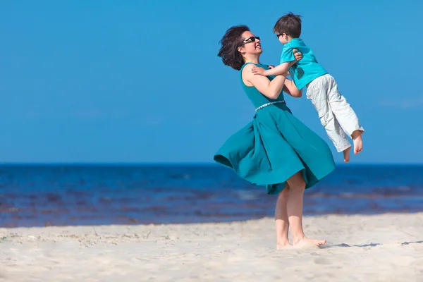 Mamma och hennes lilla son njuta av stranden — Stockfoto