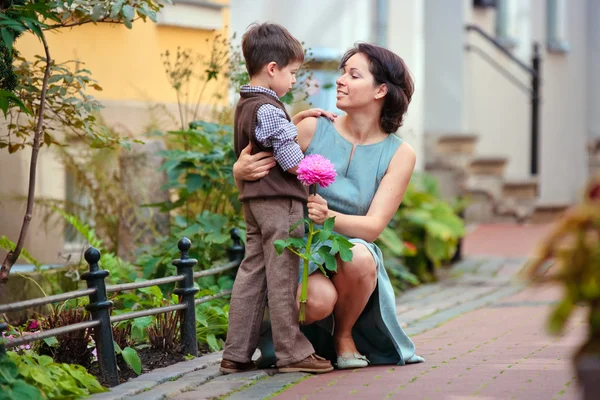 Liten pojke ger blomma till sin mamma — Stockfoto