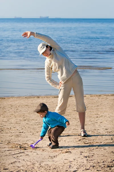 Matka a syn si pochutnávají čas na pláži — Stock fotografie