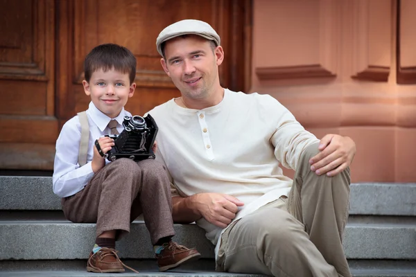 Pai e filho pequeno com câmera retro ao ar livre — Fotografia de Stock