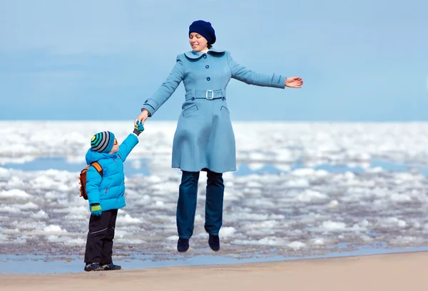Mutter und Sohn genießen Zeit am Winterstrand — Stockfoto