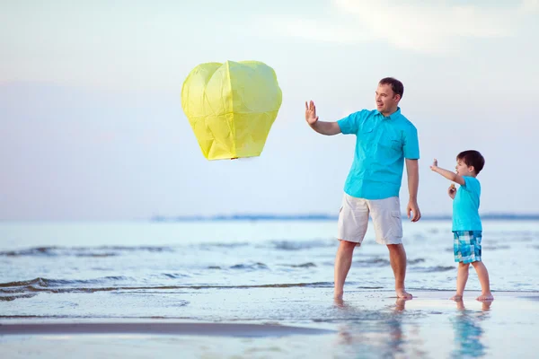 Feliz padre e hijo volando linterna de fuego juntos — Foto de Stock