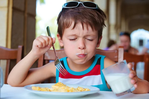 Bonito menino tendo delicioso café da manhã — Fotografia de Stock