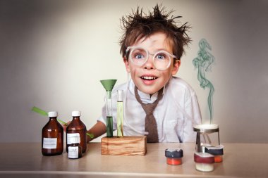 Crazy scientist. Young boy performing experiments clipart