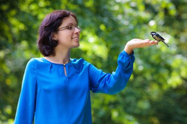 genç bir kadın büyük baştankara kuş besleme