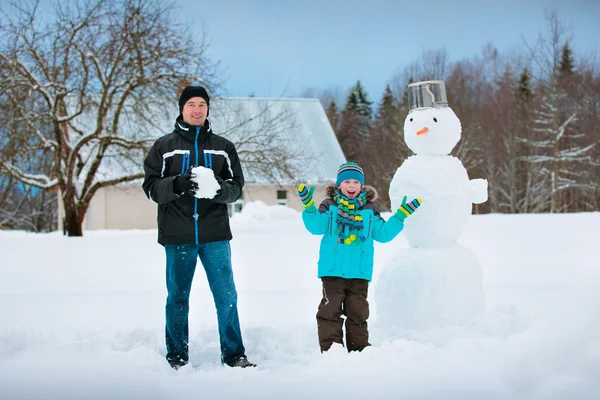 Piccolo ragazzo con suo padre che fa un pupazzo di neve — Foto Stock