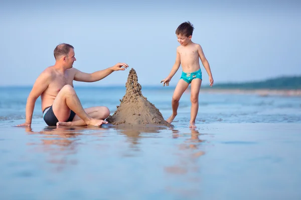 Junger Vater und Sohn bauen Sandburg am Strand — Stockfoto