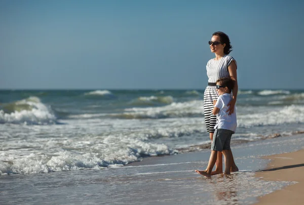 Mamma och hennes lilla son njuta av stranden — Stockfoto