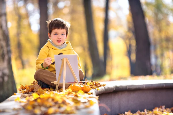 Mignon petit garçon peinture dans le parc d'automne doré — Photo