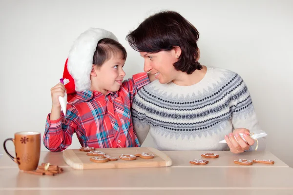 Mor och son dekorera pepparkakor cookies — Stockfoto