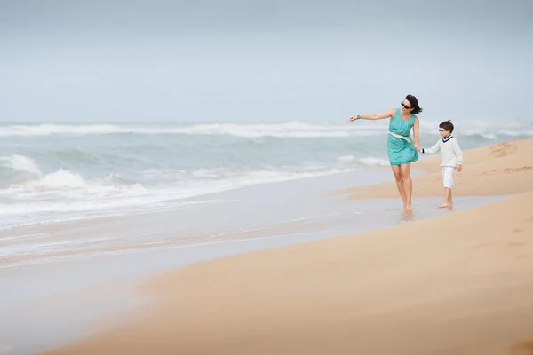 母と息子、熱帯のビーチに沿って歩く — ストック写真