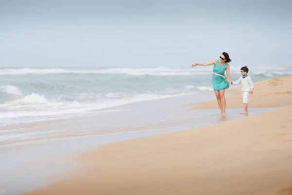 Mother and son walking along a tropical beach — Stock Photo, Image