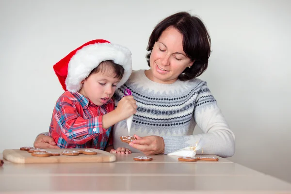 Mor och son dekorera pepparkakor cookies — Stockfoto