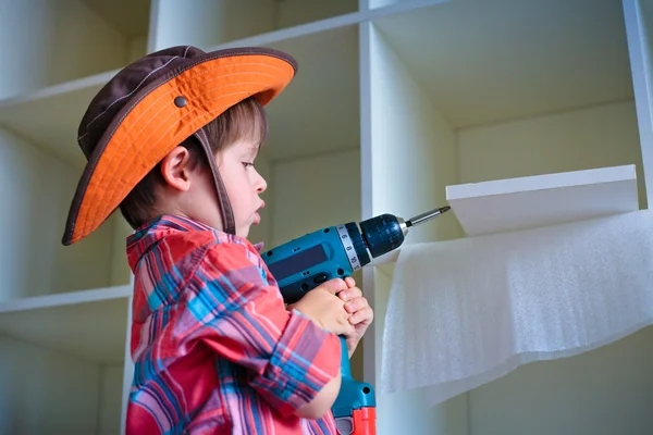 bir elektrikli tornavida kullanarak sevimli küçük çocuk
