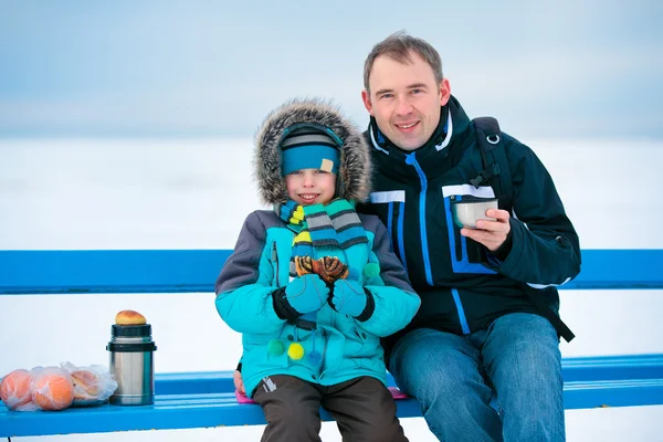 Mutlu baba ve oğul kış sahilde piknik — Stok fotoğraf