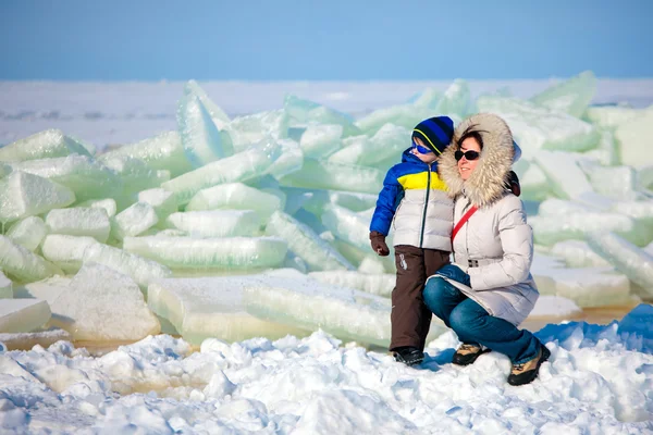 Jeune mère et son fils sur la plage glacée — Photo