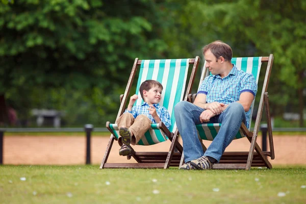 Feliz padre e hijo descansando en el parque de la ciudad —  Fotos de Stock