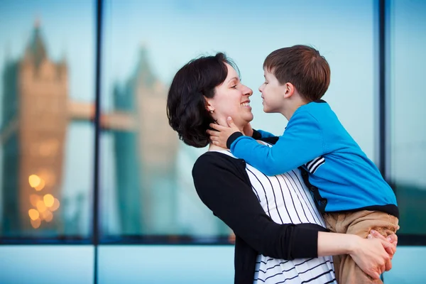 Sevgi dolu bir anne ve oğlu açık havada şehirde sarılma — Stok fotoğraf