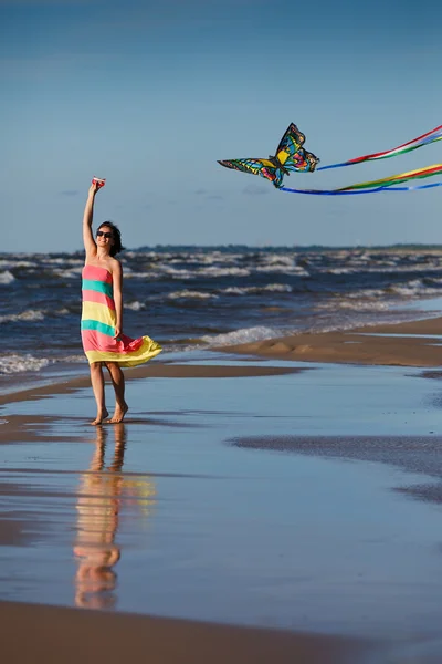Young woman playing with kite on the beach — Stock Photo, Image
