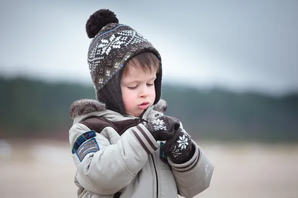 Schattige kleine jongen plezier op winter strand — Stockfoto