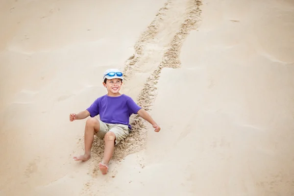 Băiatul s-a rostogolit pe panta dunelor albe ca zăpada — Fotografie, imagine de stoc