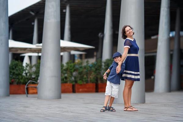 Joven madre y su hijo caminando al aire libre en la ciudad — Foto de Stock