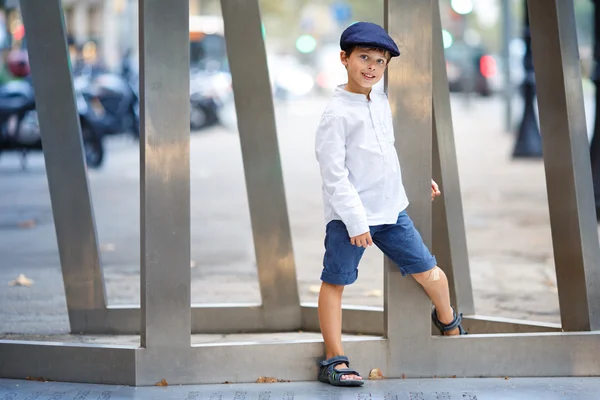 Mignon petit garçon marchant à l'extérieur en ville — Photo