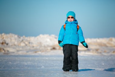 Kış sahilde oynarken sevimli küçük çocuk