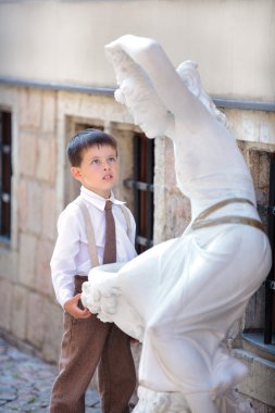 sevimli küçük çocuk beyaz heykele arıyorsunuz