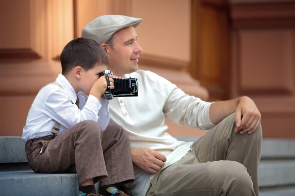 Vater und kleiner Sohn mit Retro-Kamera in der Stadt — Stockfoto