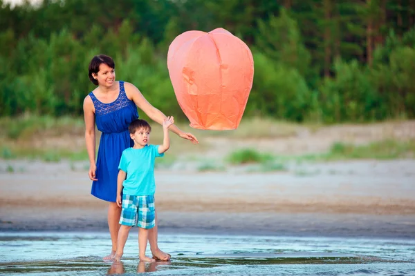 Giovane madre e figlio volare lanterna di fuoco insieme — Foto Stock