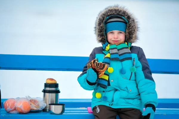 Mignon petit garçon ayant un pique-nique sur la plage d'hiver — Photo