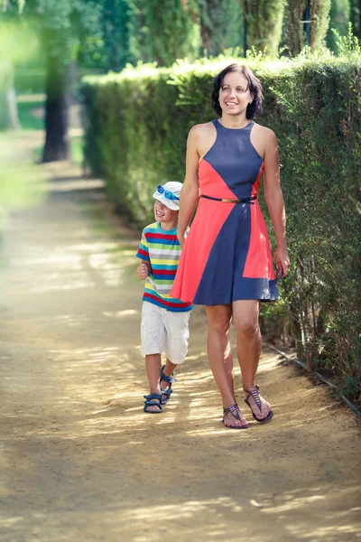 Madre y su pequeño hijo caminando en el parque de la ciudad —  Fotos de Stock