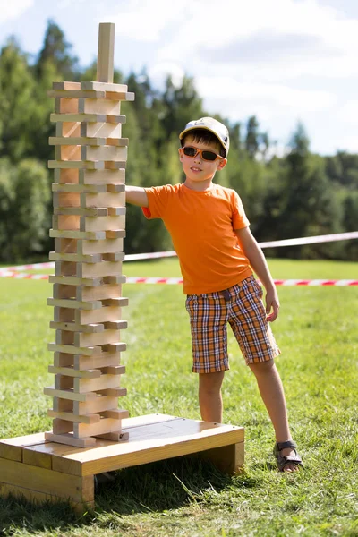 Cute little boy with wooden tower game — Stock Photo, Image