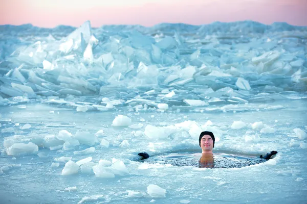 冬の水泳。氷の穴の男 ストック写真