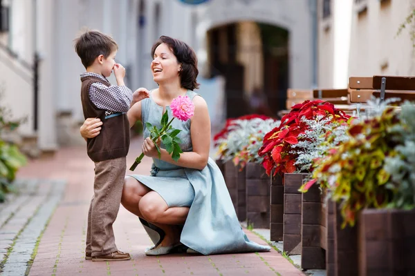 Liten pojke ger blomma till sin mamma — Stockfoto