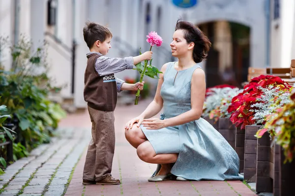 Pequeño niño dando flor a su mamá — Foto de Stock