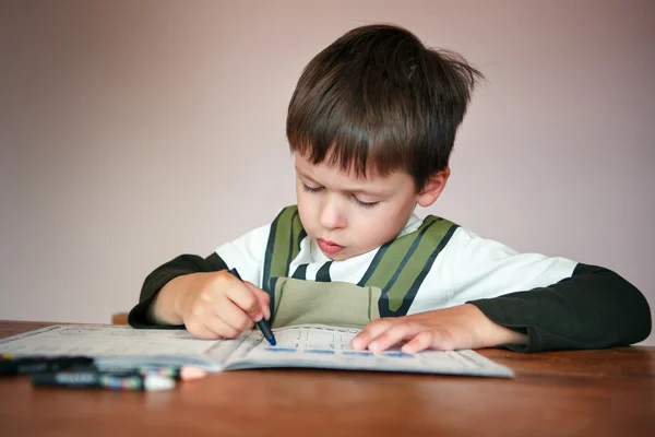 Ung pojke gör sina läxor hemma — Stockfoto