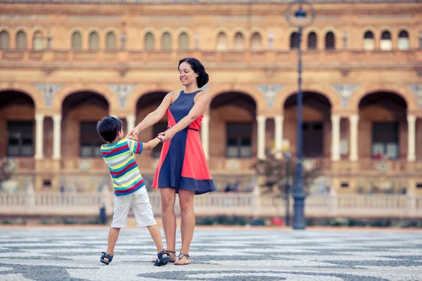 Young mother and her son playing outdoors in city — Stock Photo, Image