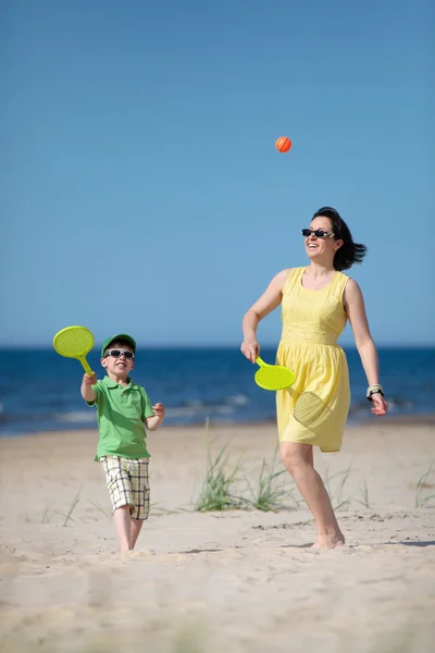 Jovem mãe e filho brincando na praia — Fotografia de Stock