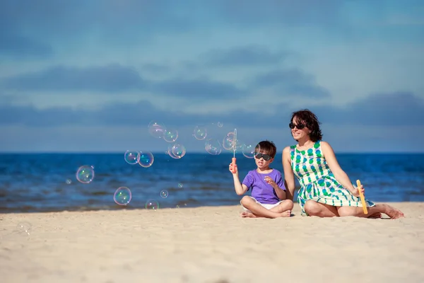 Jeune mère avec son enfant faisant des bulles de savon — Photo