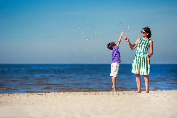 Mor och son åtnjuter tid på tropical beach — Stockfoto