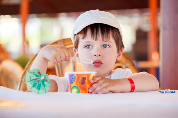 Netter kleiner Junge isst Eis im Café — Stockfoto