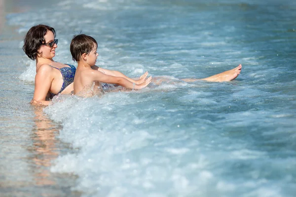 Mother and son splashing in ocean waves — Stock Photo, Image